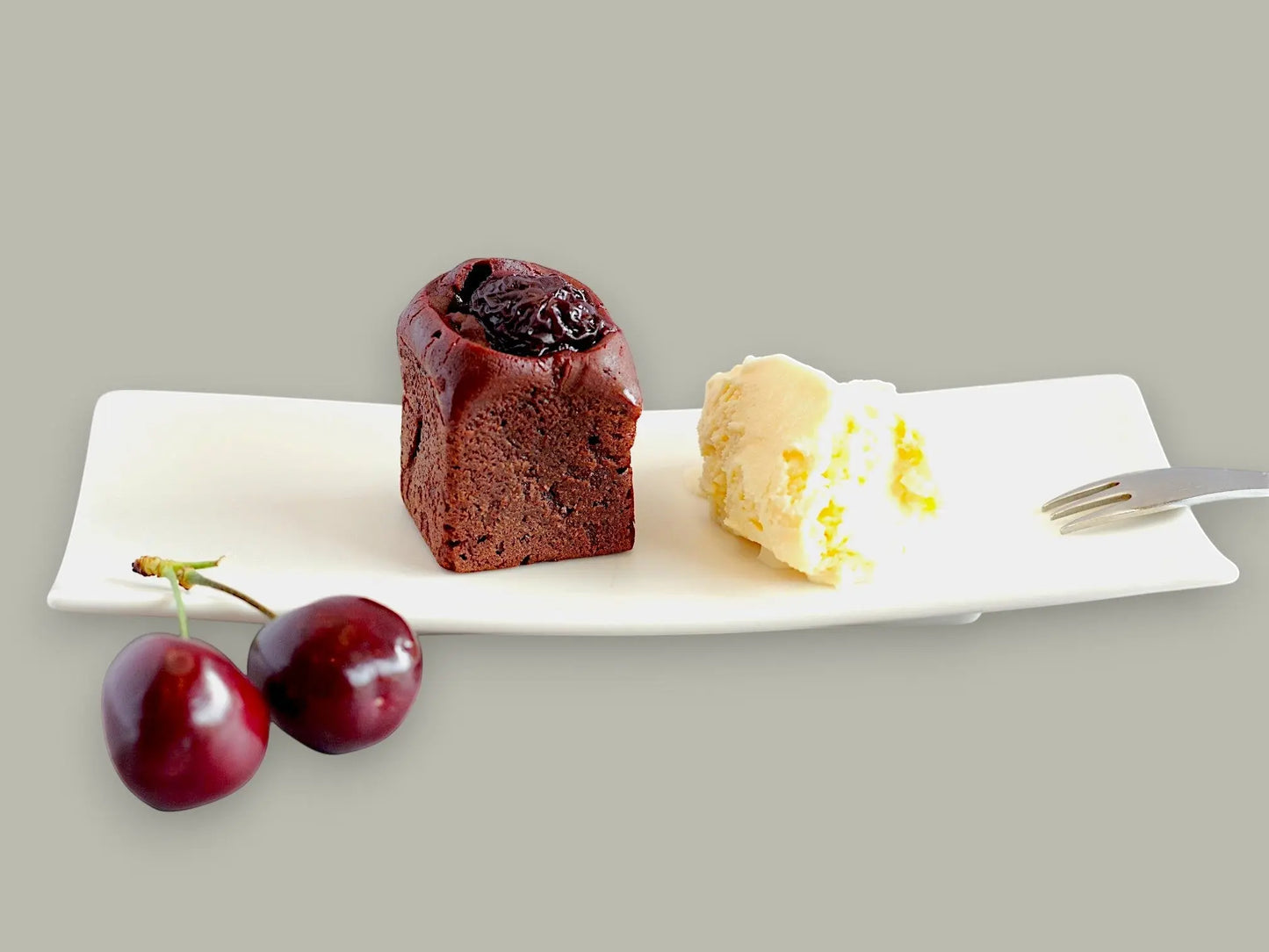 CACAOKOBO TRIBUTE カカオ工房トリビュート dark chocolate cherry brownie served with vanilla ice cream on a white plate