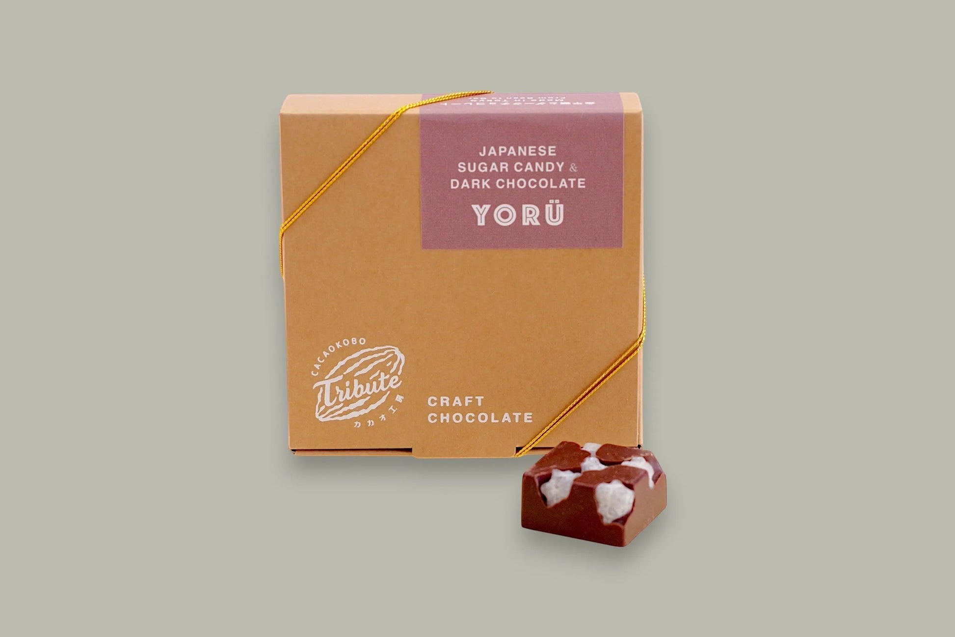 CACAOKOBO TRIBUTE Yorü Japanese Sugar Candy & Dark Chocolate box with a single piece of dark chocolate topped with white sugar candy.