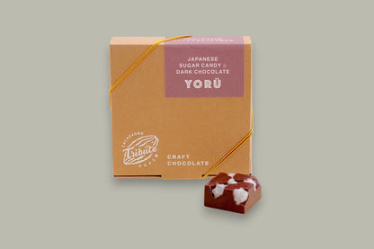 CACAOKOBO TRIBUTE Yorü Japanese Sugar Candy & Dark Chocolate box with a single piece of dark chocolate topped with white sugar candy.